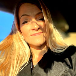 Woman with Blonde Hair and a Coat, Driving Through an Open Window in a Car