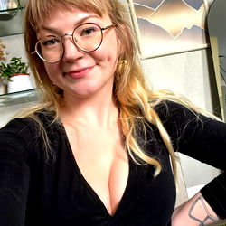 Woman in glasses, black and white, standing in front of a lamp