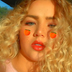 Gorgeous Ash with Wavy Hair, Wearing Pink and Eating a Peach