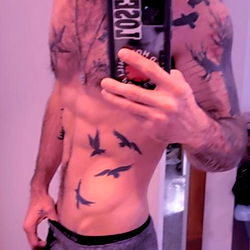 Fit Athletic Model Showcasing Tattoos and Chiseled Physique in Casual Fitness Apparel