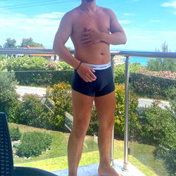 Shirtless Man in Black Boxers on Balcony