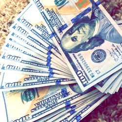 Folded 20 dollar bill with 100 US dollar notes in front of it