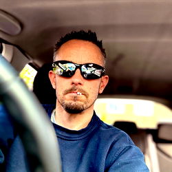 Man in sunglasses driving a car