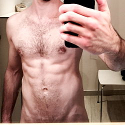 Fit and Shirtless Model Showcasing Abs in Bathroom Mirror