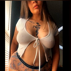 Illinois-Based Model Naughty Naomi Showcases Her Style in a Striped Tank Top and Jeans