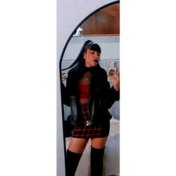 Antoceleste, a young, stylish model showcasing her unique style with black and red plaid mini skirt and leather jacket. 