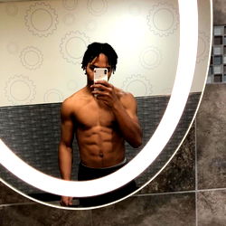 Fitness Model Showcasing Abs in Gym Mirror