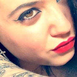 OnlyFans Model DominantAngelina, A Tattooed Vixen in Red Lips and Earrings