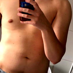 Young Man Showcasing Abs in Bathroom Mirror