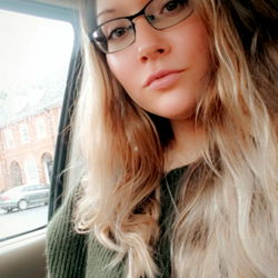 Glamorous Woman in Sweater and Glasses Smiling for OnlyFans