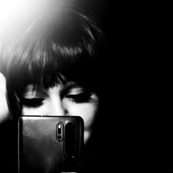 Mysterious Brina in a Dark Background, Holding a Phone