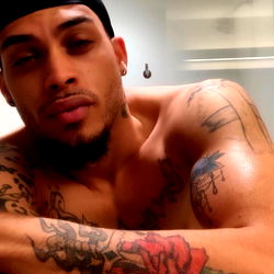 Stylish Tattooed Man in Black Cap and Earrings