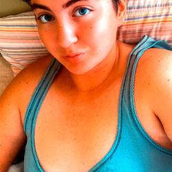 A young, blue-haired individual relaxing at home