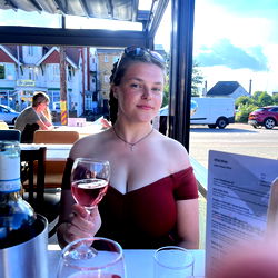 A young woman enjoying wine at an outdoor restaurant