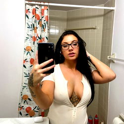 Kayla, a beautiful Fort Lauderdale OnlyFans model posing in front of a bathroom mirror with her phone