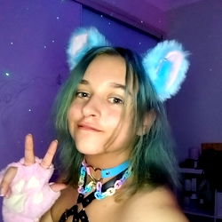 Aerafae, a 21-year-old Brisbane-based OnlyFans model with blue hair and cat ears, posing for a selfie with heart fingers.