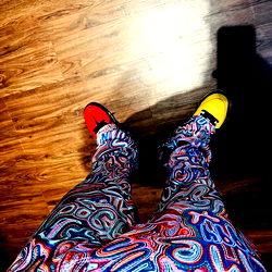 Bold and Colorful Pants on a Model Standing Against a Wall