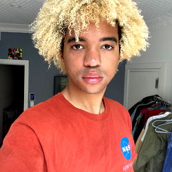 Stylish Blonde Man with Curly Hair in a Mirror