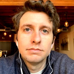 A man wearing headphones in a cafe-like setting