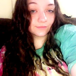 Woman with long hair, glasses and a graphic tee posing for OnlyFans