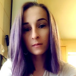 Stylish woman with long purple hair in a kitchen