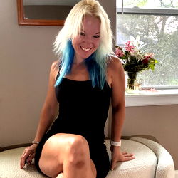 Smiling OnlyFans Model with Blue Hair, Sitting on Sofa