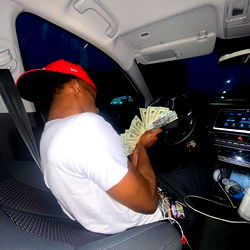 A person sitting in a car with money in their hand