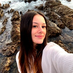 Baylee Haenga posing in front of a picturesque ocean backdrop