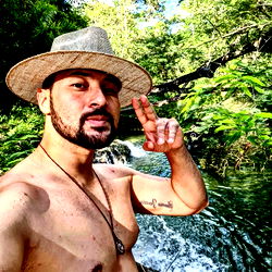 Shirtless Man Posing with River in Tropical Location