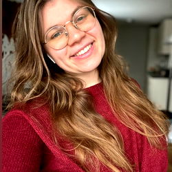 Lina, a young lady with glasses and red hair, radiating joy and positivity.