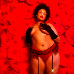 Thee Vixxxen's Seductive Portrait on Red Backdrop