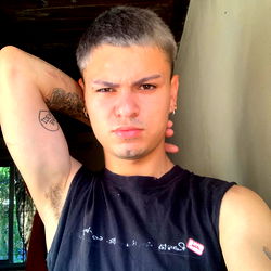 Tattooed Man in V-Neck Shirt and Shorts