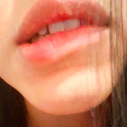 A woman with red lips and a small nose ring