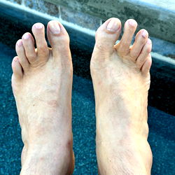 A Man's Bare Feet in a Pool