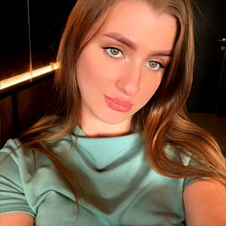 A young woman takes a selfie in a sleek setting.