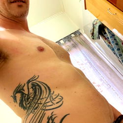 Shirtless Man Showcasing Tattoos,