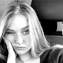 Stylish Blonde Model with Hand on Chin and Slightly Pouty Expression