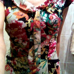 Woman in Flowered Blouse Standing Against Wall