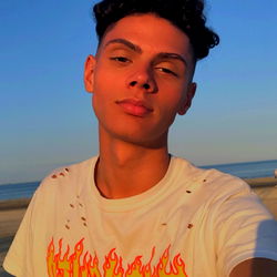 Toni Cruz, a Boston-based model, poses for a beachfront selfie with a vibrant yellow shirt and sneakers