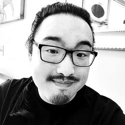 Wholelottanope - A Young Asian Man Smiling with Glasses and a Beard