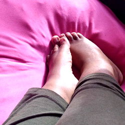 Female Foot in Pair of Jeans on Pink Cushion