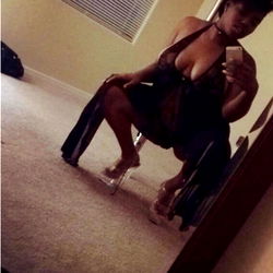 Essence, an Arizona-based model, posing for a mirror selfie in a chic outfit.