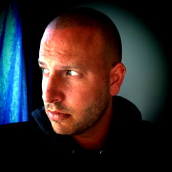 Bearded Man with Shaved Head, Staring into Camera