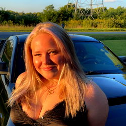 A Blonde Woman with a Tattoo in Her Hand, Smiling at the Camera