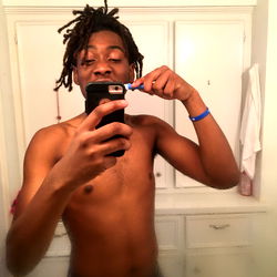 A man in a bathroom brushing his teeth