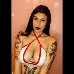 Agostina Goroso, an OnlyFans model with tattoos and a striking outfit, poses for the camera.