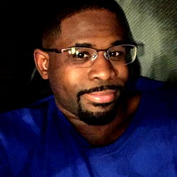 Smiling Guy in Blue Shirt, Glasses and Goatee, Sitting on Couch, Texas