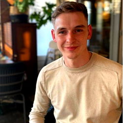 Huge Stefner, a young man with blond hair and tattoos, poses in a restaurant setting.