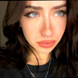 A person with a unique hairstyle and tattooed eyebrows