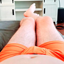 Ultimate Fans Model Showcases Orange Swimsuit in Relaxed Setting